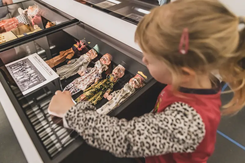 Besucherinnen in der Ausstellung an einer Schublade