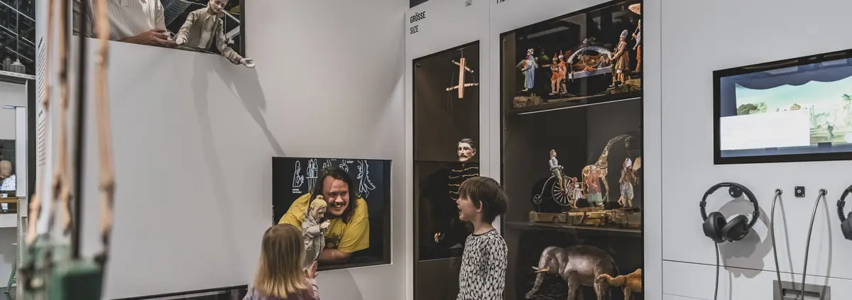 Besucherinnen in der Ausstellung an einer Schublade