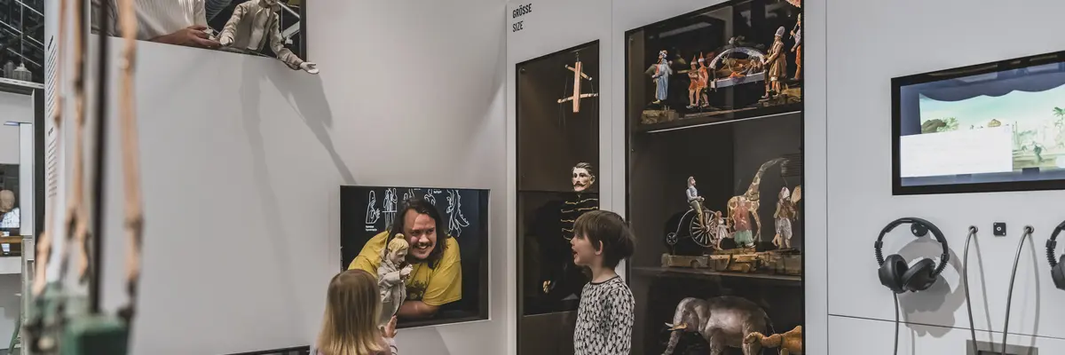 Besucherinnen in der Ausstellung an einer Schublade