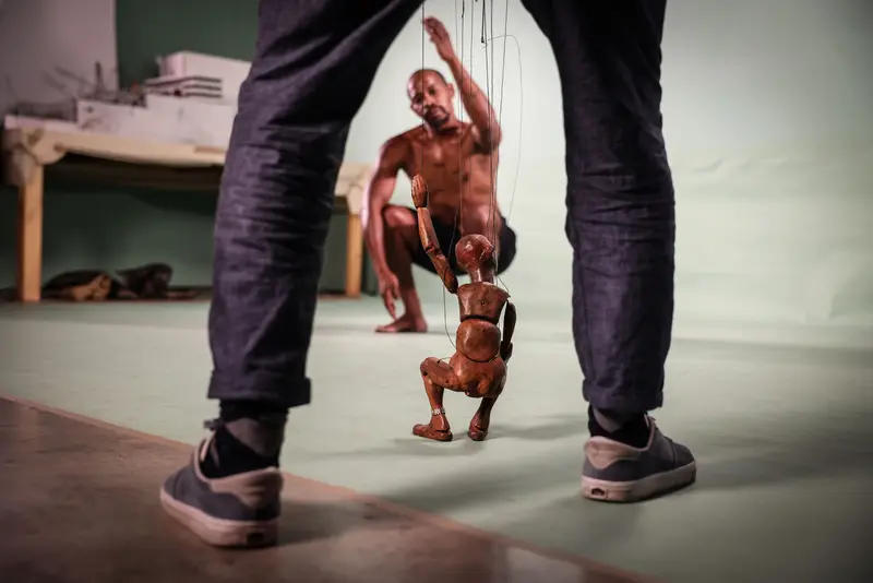 Holzpuppe zwischen den Beinen eines Menschen