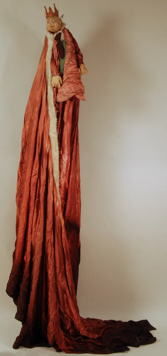 Puppe mit Krone und einem langen, roten Umhang